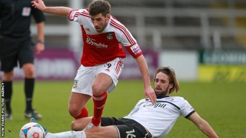 Mark Carrington of Wrexham is tackled by Frankie Artus of Hereford United
