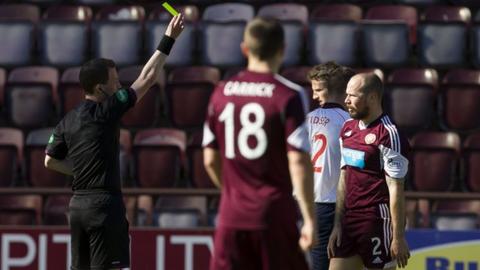 Hearts player Jamie Hamill is shown a second yellow card against Ross County