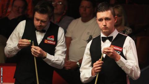 Kyren Wilson assesses a shot while Ricky Walden chalks up