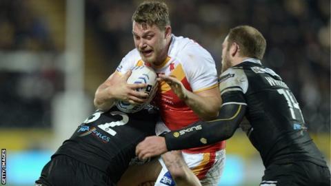 Elliott Whitehead of Catalan Dragons (centre) is tackled by Jordan Rankin and Richard Whiting of Hull FC