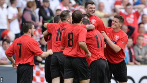 Hurlford players mob Stewart Kean after his early penalty