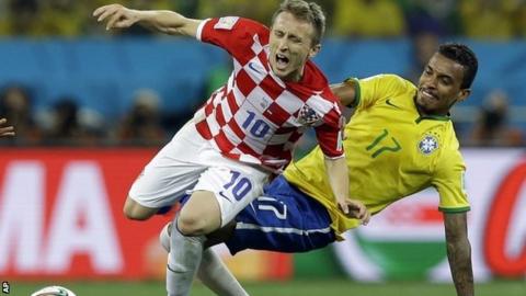 Luca Modric is tackled by Brazil's Luiz Gustavo