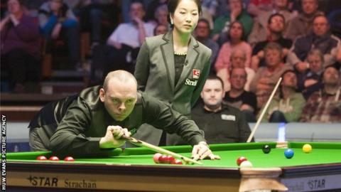 Stuart Bingham pots as match referee Zhu Ying watches