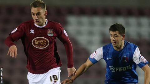 Louis Moult carries the ball while being followed by Lloyd James of Leyton Orient