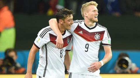 Mesut Ozil and Andre Schurrle celebrate as Germany beat Algeria 2-1