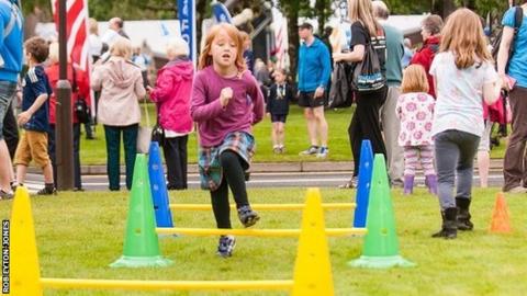 young girl runs on a simple hurdling course