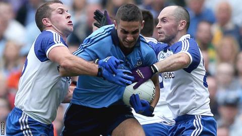 Two Monaghan players tackle Dublin's James McCarthy