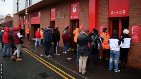 Fans queue at a turnstile