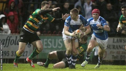 Jack Dixon of Newport Gwent Dragons is tackled by George North and Dylan Hartley of Northampton Saints