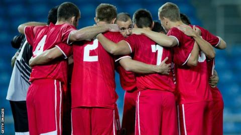Captain Roy Chipolina gives a team-talk to his Gibraltar side