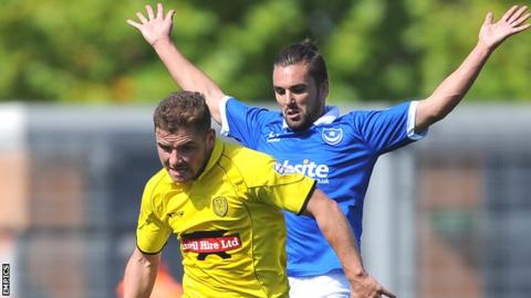 Alex MacDonald (left) challenged by Portsmouth's Ricky Holmes