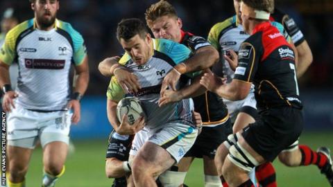 Aaron Jarvis of Ospreys is tackled by Lewis Evans
