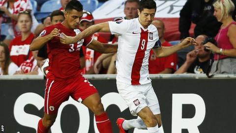 Joseph Chipolina (left) vies with Poland"s forward Robert Lewandowski