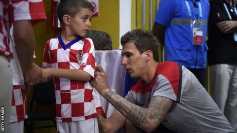 Mario Mandzukic signs a young fan's shirt