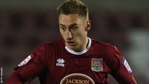 Louis Moult carries the ball while being followed by Lloyd James of Leyton Orient