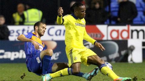 Shrewsbury Town defender Mickey Demetriou tackles Chelsea striker Didier Drogba