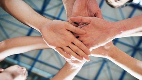 looking up at hands all piled on eachother