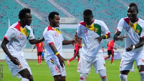 Guinea players celebrate after beating Uganda