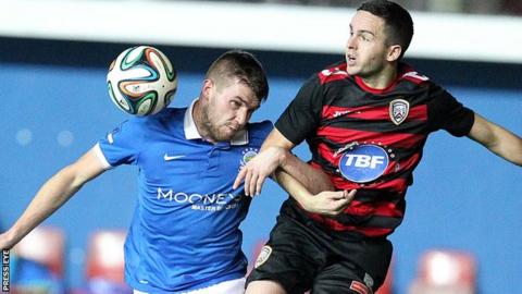 Linfield midfielder Stephen Lowry beats Coleraine's Neil McCafferty to the high ball