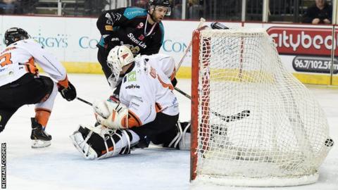Evan Cheverie of the Belfast Giants shoots past Frank Doyle of the Sheffield Steelers