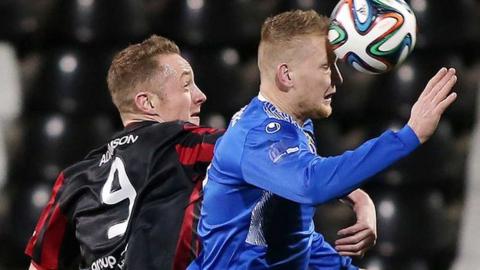 Crusaders forward Timmy Adamson is beaten to the high ball by Dungannon's David Armstrong
