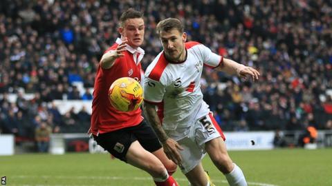 Bristol City's Matt Smith (left) and Mk Dons' Kyle McFadzean battle for the ball