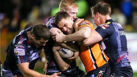 Wigan's Tony Clubb, Liam Farrell and Dan Sarginson tackle Castleford's James Clare