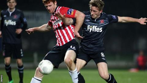 Derry's Sean Houston holds off Dundalk midfielder John Mountney