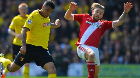 Troy Deeney shoots as Adam Clayton tries to block