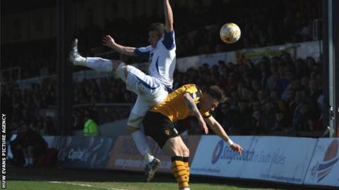 Craig Jones of Bury collides with Miles Storey of Newport County