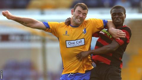 Mansfield's Matt Rhead challenges Peterborough United's Gabriel Zakuani