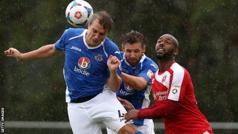 Kieron St Aimie (right) challenges Paul Reid and Jamie Collins