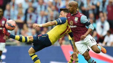 Fabian Delph competes with Arsenal's Mesut Ozil at Wembley