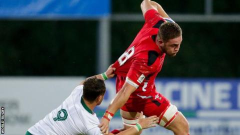Wales number eight Harrison Keddie is tackled by Ireland scrum-half Charlie Rock