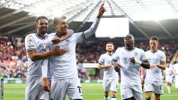 Joel Piroe celebrates alongside Cyrus Christie after putting Swansea in front with an emphatic volley