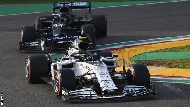 Pierre Gasly drives ahead of Lewis Hamilton