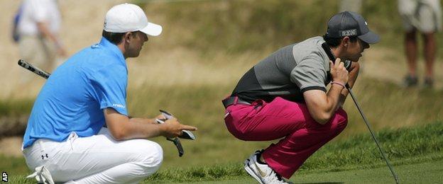 Jordan Spieth (left) and Rory McIlroy line up putts on the first on Thursday