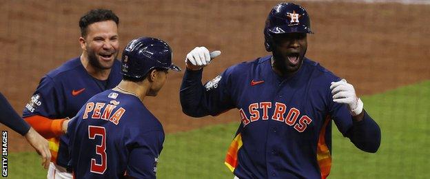 Jose Altuve and Jeremy Pena celebrate a home run by Yordan Alvarez (right)