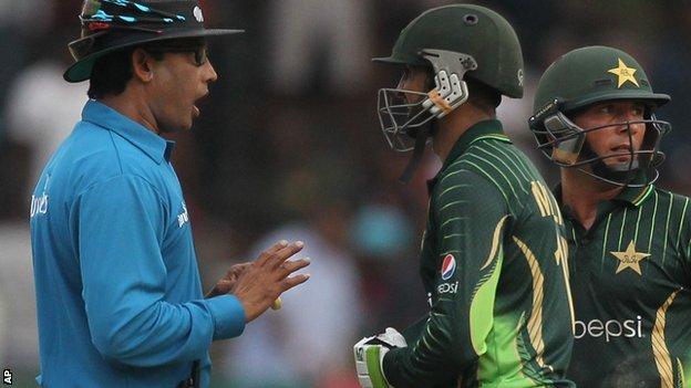 Umpire Ruchira Palliyaguruge talks to Pakistan's batsman after the ODI with Zimbabwe was halted because of bad light