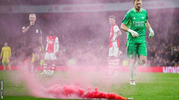 A flare on the pitch during Arsenal's League Cup defeat by Liverpool on Thursday
