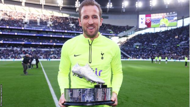 Harry Kane holds a trophy after becoming Tottenham's record goalscorer