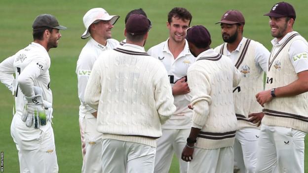 Surrey players congratulate Tom Lawes after taking the wicket of Northamptonshire batsman Lewis McManus