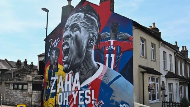 A mural of Wilfrid Zaha painted connected  the broadside  of a house