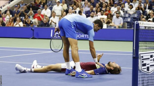 Novak Djokovic tries to help Daniil Medvedev off the court