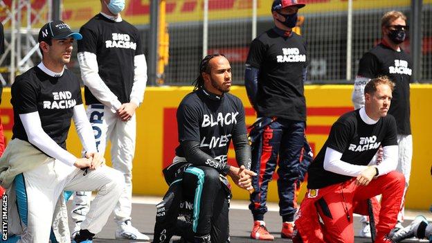 Lewis Hamilton and fellow F1 drivers take part in an anti-racism protest before Sunday's British Grand Prix