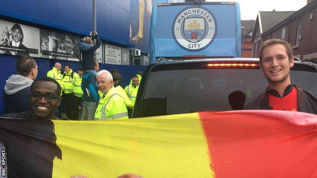 Edgar and Thomas hold aloft a Belgium flag in front of the Man City team bus outside Goodison Park