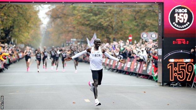Eliud Kipchoge celebrating while crossing the finishing line after running a marathon in under two hours