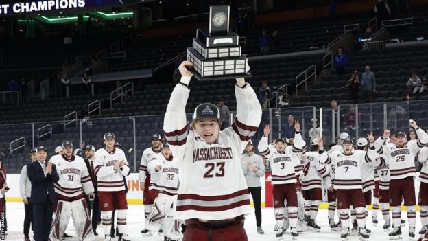 Scott Morrow lifts the Lou Lamoriello trophy after the Hockey East Championship game between the Massachusetts Minutemen and Connecticut Huskies