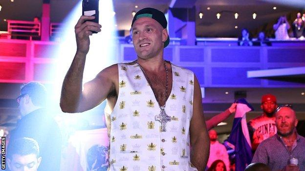 Tyson Fury takes a photo with his phone