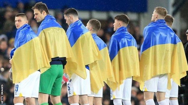 Everton players draped in the Ukraine flag